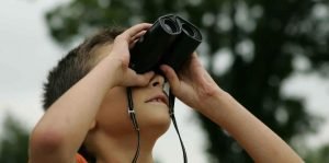 This is a picture of a boy with binoculars for an article Why Market Intelligence can help any size company by Octopus Competitive Intelligence market intelligence and competitor analysis