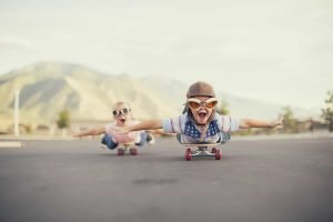 This is a picture of a A young boy and girl are wearing flying goggles while outstretching their arms to attempt flying while on skateboards. They have large smiles and are imagining taking off into the sky. representing a What we do by Octopus Competitive Intelligence. How Southwest Airlines Built a Successful Low-Cost Business Model and Managed Through Industry Turmoil