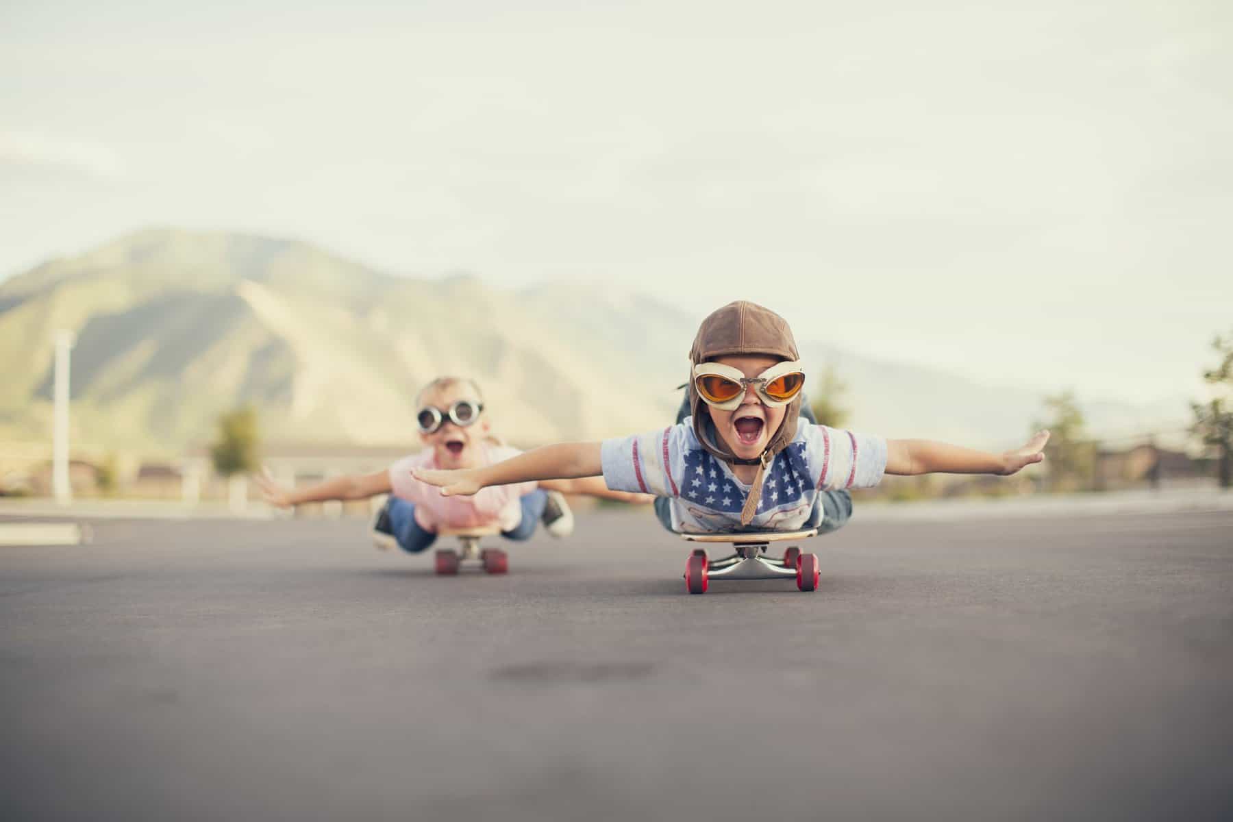 This is a picture of a A young boy and girl are wearing flying goggles while outstretching their arms to attempt flying while on skateboards. They have large smiles and are imagining taking off into the sky. representing a What we do by Octopus Competitive Intelligence. How Southwest Airlines Built a Successful Low-Cost Business Model and Managed Through Industry Turmoil