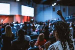 This is a picture of a Girl with her hand up in a seminar for an article entitled 5 keys to conducting a market opportunity analysis by Octopus Intelligence. Solving problems with Competitive Intelligence, common sense and market analysis. Marketing research analysis