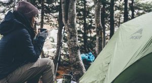This is a picture of lady in the morning outside a tent for an article called Competitive Intelligence field tradecraft by Octopus Competitive Intelligence answering questions you need to ask with Competitor Analysis