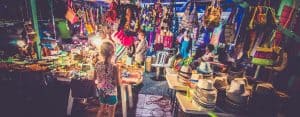 This a picture of a girl inspecting a market stall for an article called What makes an excellent Market Intelligence and OSINT Analyst by Octopus Competitive Intelligence consultancy for Competitor Analysis and market intelligence services. Customer Market Distribution Intelligence Questions. Intelligence market research important questions for small business