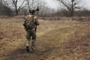 This is picture of an alert Solider walking through a field by specna arms for an article called What's Competitive Intelligence got to do with situational Awareness by Octopus Competitive Intelligence Market Intelligence Competitor Analysis get in touch no obligation chat. What's Market Intelligence got to do with situational Awareness