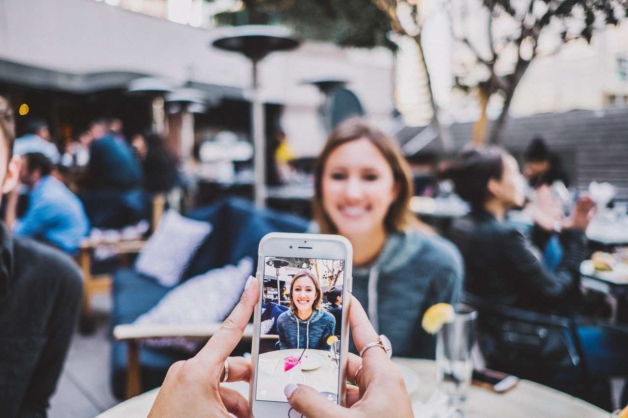 This is a picture of a girl having a photo taken for a social media post for a case study called Social Media subscriber Competitor Analysis and Win-Loss Analysis Case Study by Octopus is a Competitive Intelligence Competitor Analysis focused on creating certainty. The Role of Social Media Metrics in Shaping B2B Market Insights