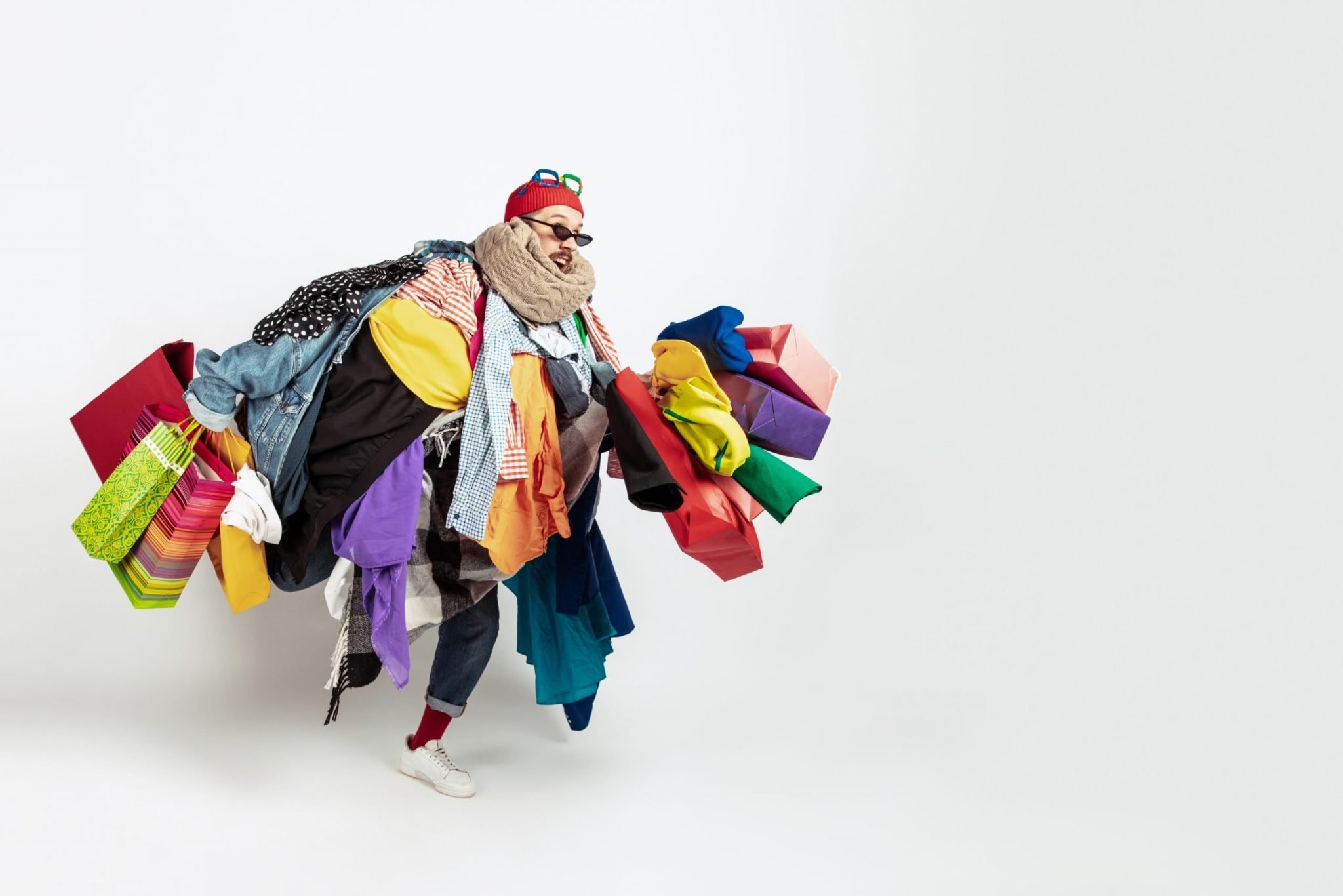 This is an image of a man with too many shopping bags representing data overload. for an article called Why is data the least important part of Competitive Intelligence by Octopus Competitive Intelligence consulting agency research your competitors