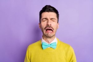 This is an image of of brunet crying guy wear yellow sweater isolated on pastel lilac colour background for an article called Can Competitive Intelligence disappoint the reader? Here are five reasons by Octopus Competitive Intelligence consulting agency research your competitors