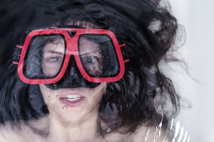 This is an image of a lady using goggles in a bath for an article called The Power of the Key Assumptions Check in Competitor Analysis deep dive to find competitive advantage by octopus competitive intelligence agency octopus competitor analysis companies